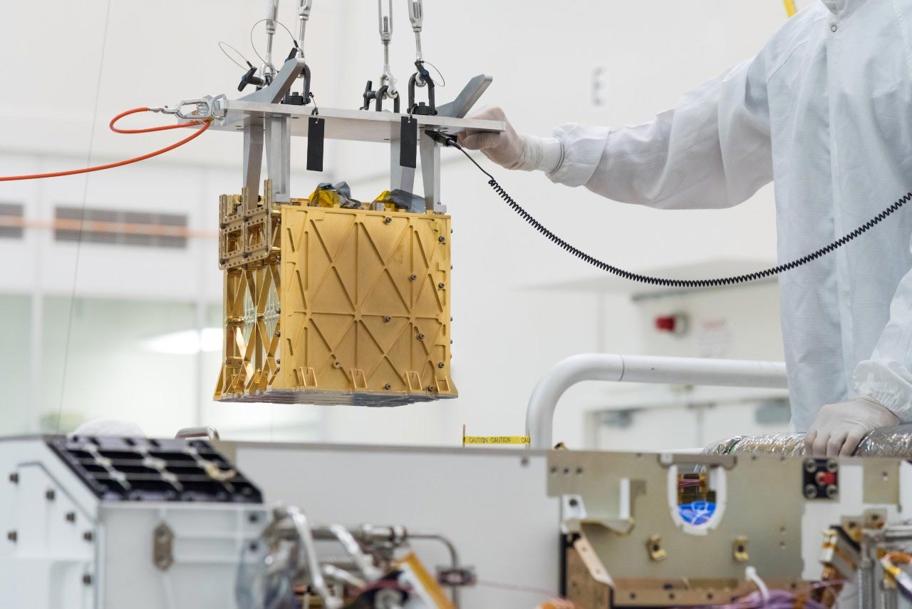 ​​​​​​​Technicy z Jet Propulsion Laboratory NASA opuszczają instrument Mars Oxygen In-Situ Resource Utilization Experiment (MOXIE) do wnętrza łazika Perseverance.