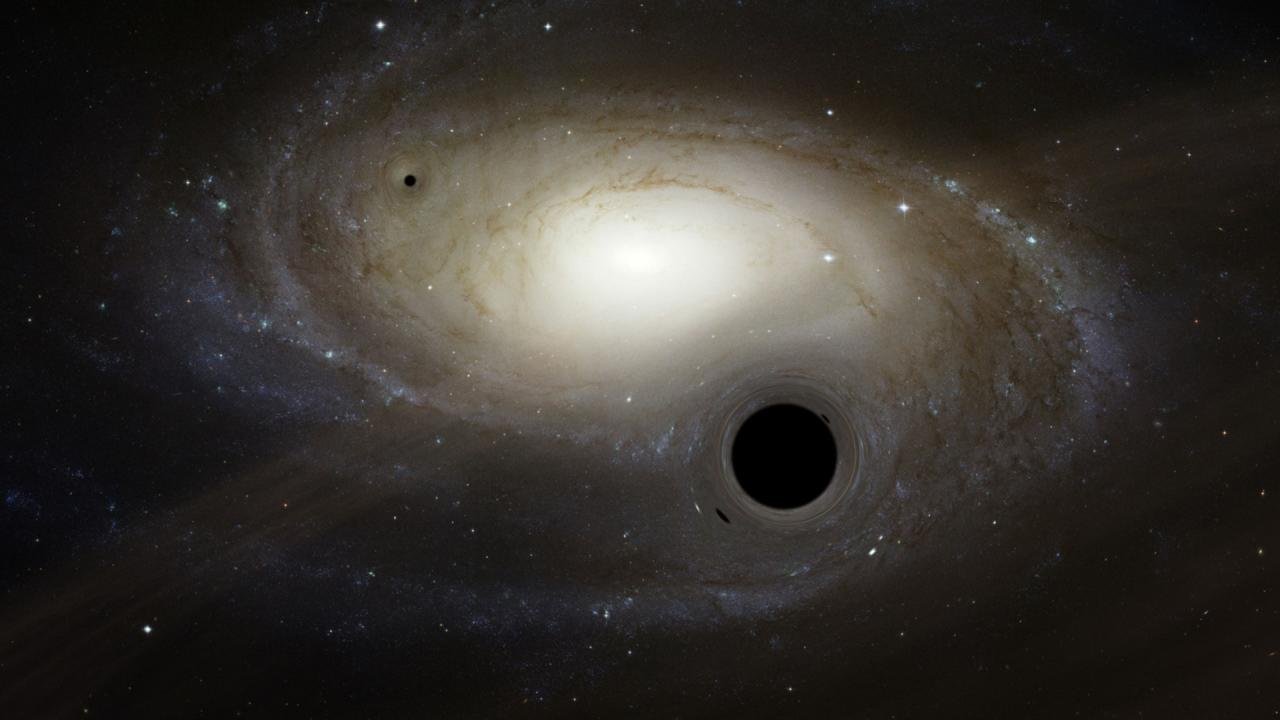 Wizja artystyczna kilku czarnych dziur o masie pośredniej poruszających się w pobliżu galaktyki.