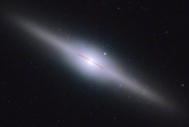 Galaktyka ESO 243-49, leżąca 300 milionów lat świetlnych od Ziemi, ma w swym centrum nowo odkrytą czarną dziurę HLX-1 o masie pośredniej. Strzałka wskazuje jej dokładną lokalizację. Źródło: NASA, ESA and S. Farrell (U. Sydney).