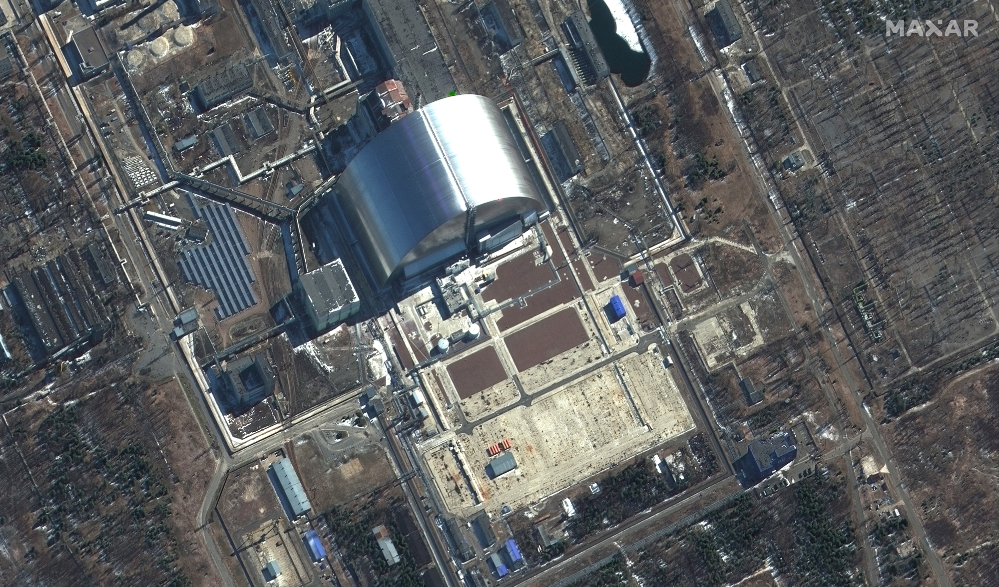 Zbliżenie na sarkofag przykrywający nieczynny reaktor jądrowy w elektrowni w Czernobu – zdjęcie z 10 marca 2022. Źródło: ©2022 Maxar Technologies
