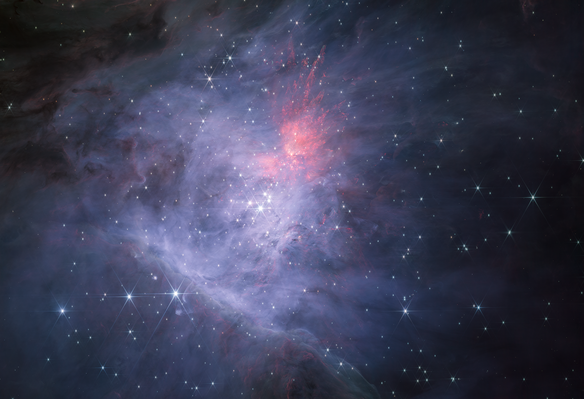 Na ilustracji: Unikalny widok centralnej części Mgławicy Oriona i Gromady Trapez w kamerze NIRCam współpracującej z Teleskopem Webba. Ta mozaika zdjęć w bliskiej podczerwieni (bardziej „krótkofalowy” zakres czułości kamery NIRCam → cztery filtry o średnich długościach fali λ ~ 1,40–1,62–1,87–2,12μm). Źródło (CC BY-SA 3.0 IGO): NASA, ESA, CSA / M. McCaughrean, S. Pearson