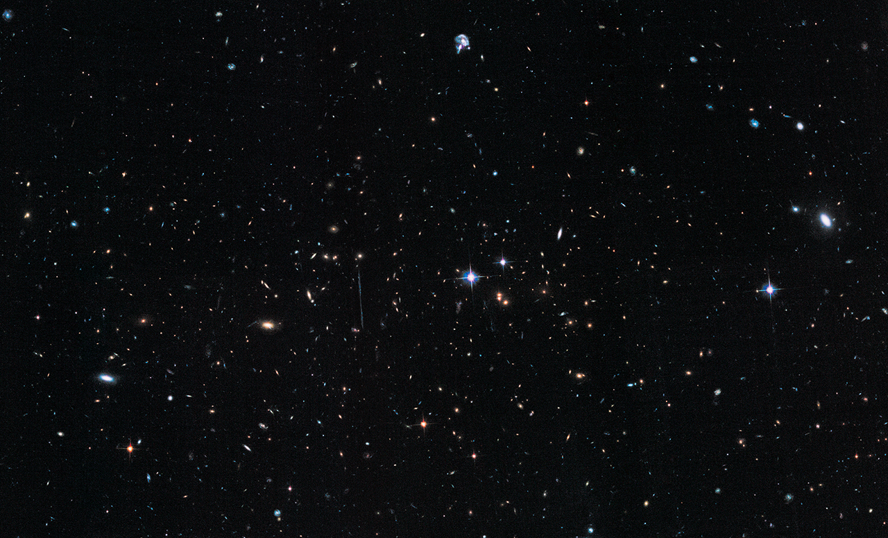 Na ilustracji: Zdjęcie gromady galaktyk El Gordo („Grubas”) zrobione przez Kosmiczny Teleskop Hubble’a i opublikowane w 2014 roku. Tutaj barwie niebieskiej, zielonej i czerwonej odpowiadają filtry z zakresu optycznego odpowiednio o długościach fali λλ = 0,625 / 0,775 / 0,850 μm. Źródło: NASA, ESA