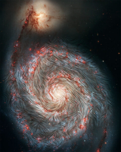 Linie pola magnetycznego wykryte przez obserwatorium lotnicze SOFIA nałożone są na optyczne zdjęcie Galaktyki Wir (M51) wykonane przez Kosmiczny Teleskop Hubble'a.