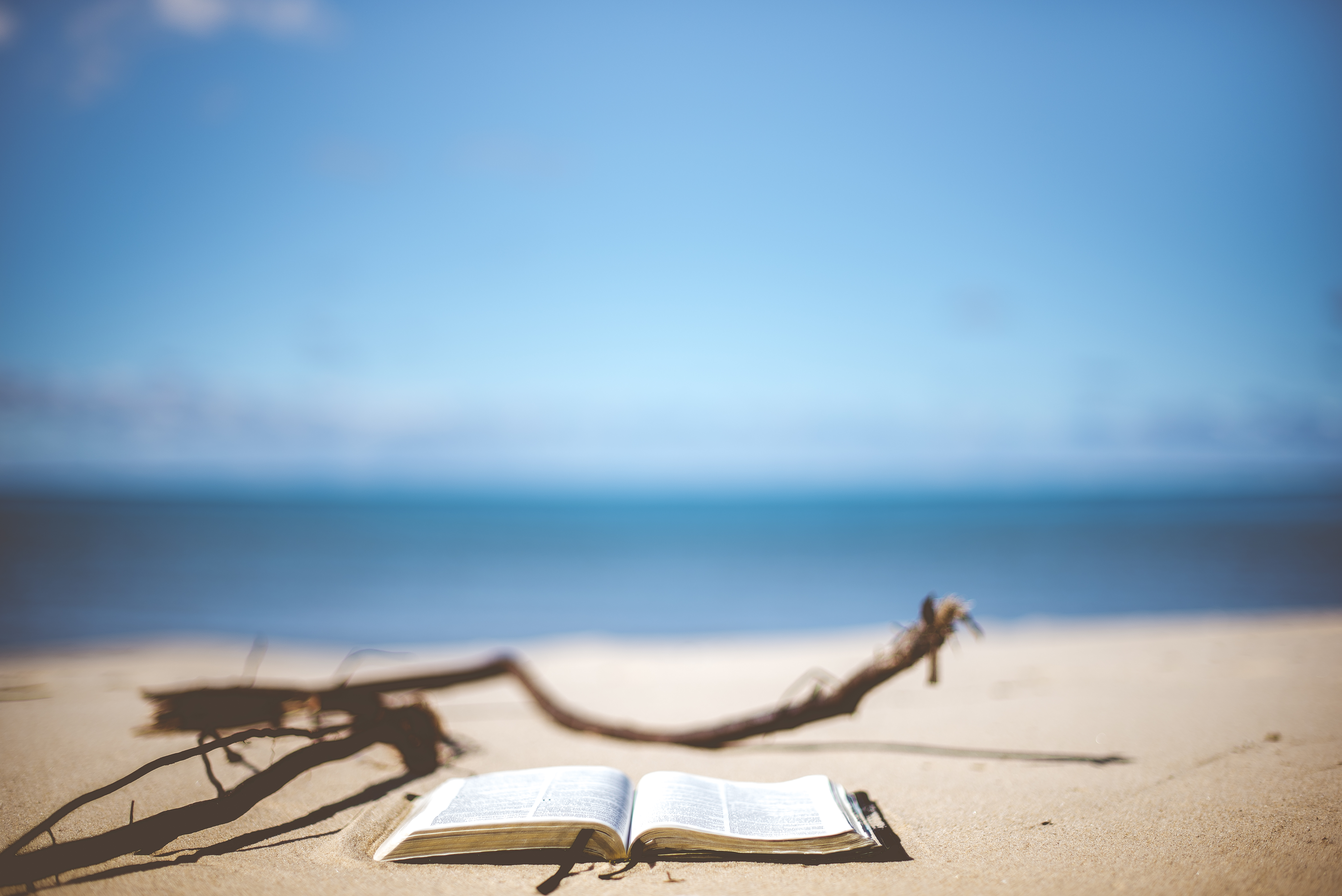Otwarta książka na piasku nad morzem