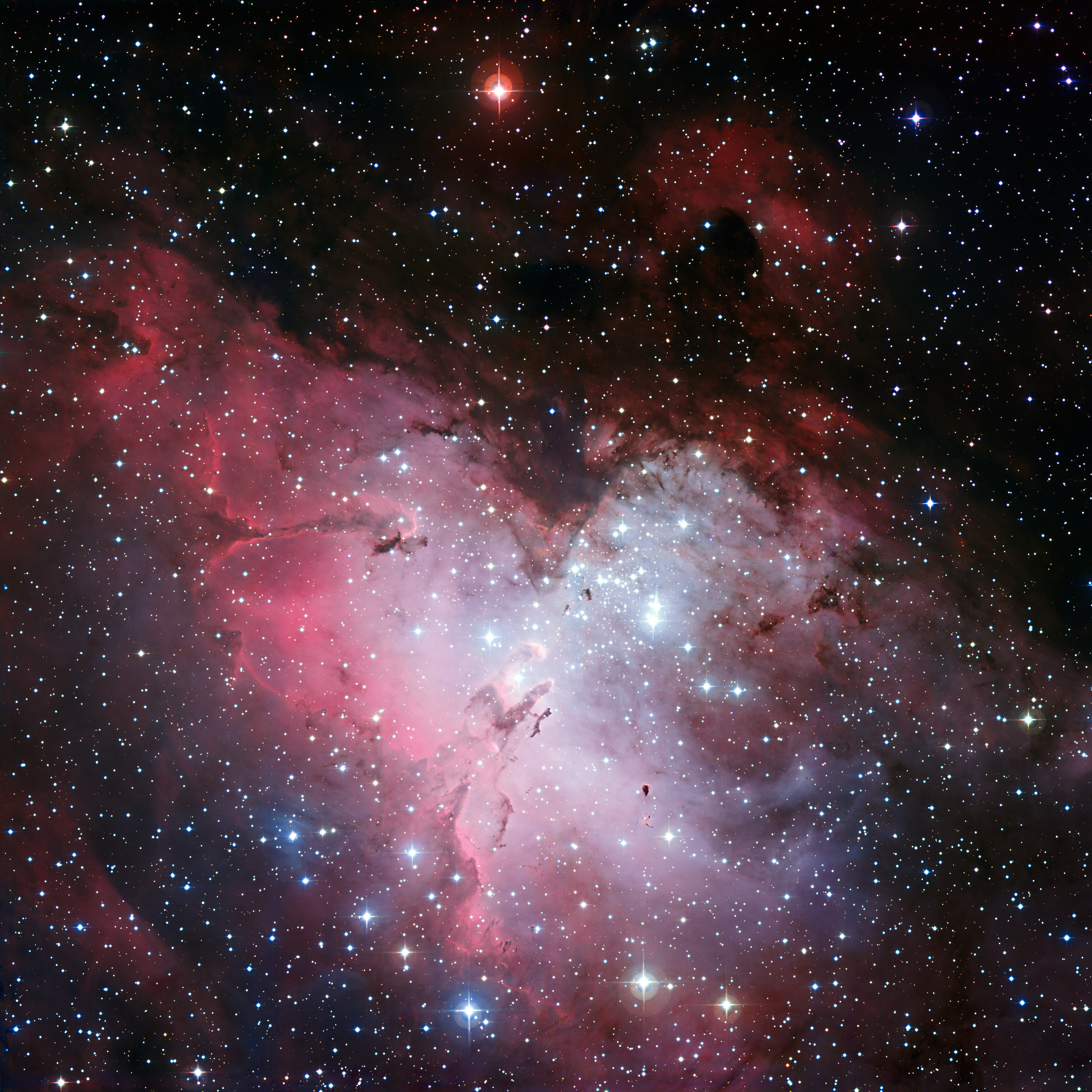 Trójkolorowa (B,V,R) mozaika obrazów Mgławicy Orzeł (M16 lub NGC 6611) uzyskana za pomocą 2,2m teleskopu MPG/ESO w Obserwatorium La Silla (Chile). Cała mgławica rozciąga się na ~70 x 55 l.św., a w pobliżu środka zdjęcia widać tzw. Filary Stworzenia w wielkości ~4-5 l.św. Ta panorama o dużym polu widzenia prezentuje również kilka innych obszarów tworzenia się gwiazd, jak również ogromną liczbę gwiazd przed i za Mgławicą Orzeł. Filary Stworzenia są oświetlone przez gromadę jasnych gwiazd NGC 6611 (u góry po prawej względem Filarów Stworzenia), w której znajdują się masywne i gorące gwiazdy. W lewej-górnej ćwiartce zdjęcia widać jeszcze jeden duży filar zwany obrazowo „Iglicą” lub „Czarnym Filarem” (ang. „Spire” / „Black Pillar”) o długości około 9,5 l.św. Źródło: ESO