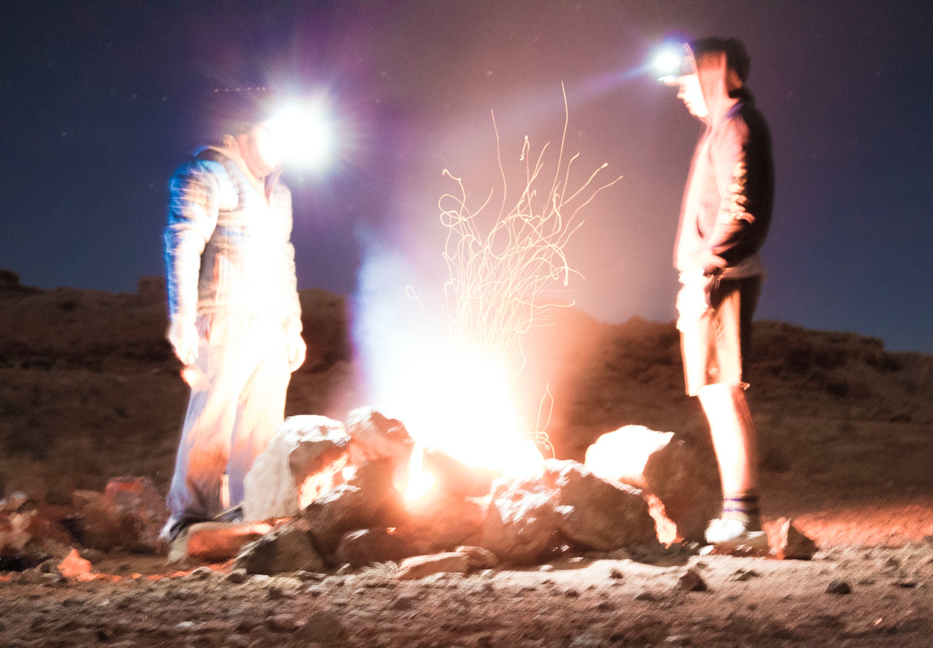 Dwóch mężczyzn stojących przy ognisku