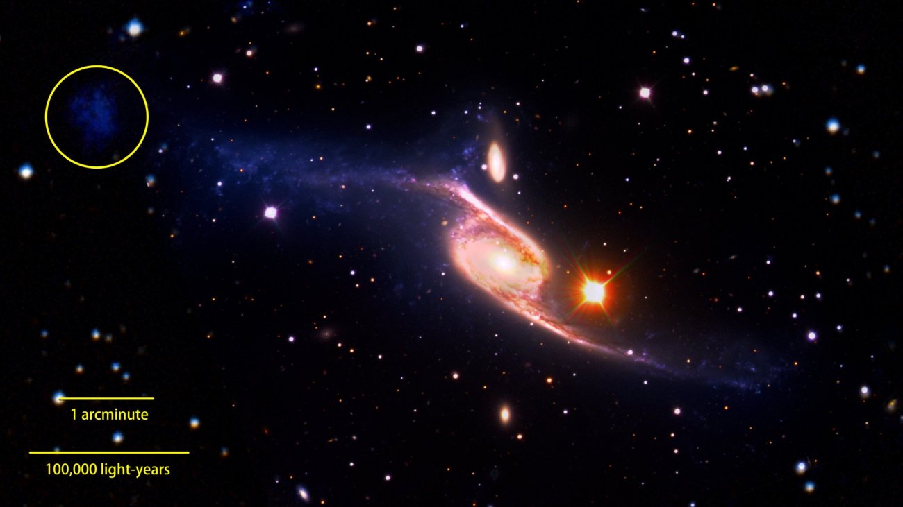 Zdjęcie galaktyki spiralnej NGC 6872 złożone z danych z teleskopów VLT, GALEX i Spitzer. Kółkiem zaznaczono obiekt widoczny w zakresie ultrafioletowym, który może być galaktyką karłowatą. Źródło: NASA Goddard Space Flight Center/ESO/JPL-Caltech/DSS.