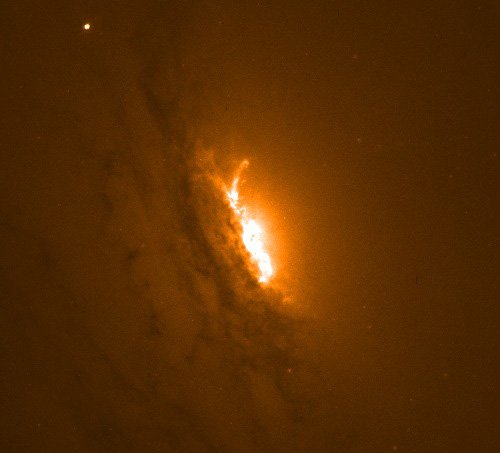 Zdjęcie z Kosmicznego Teleskopu Hubble'a, przedstawiające centralną część galaktyki IC 5063. Jaśniejszy obszar w samym środku to miejsce, w którym dżety plazmy zasilane i napędzane przez supermasywną czarną dziurę z ogromną prędkością wyrzucają materię poza granice galaktyki.