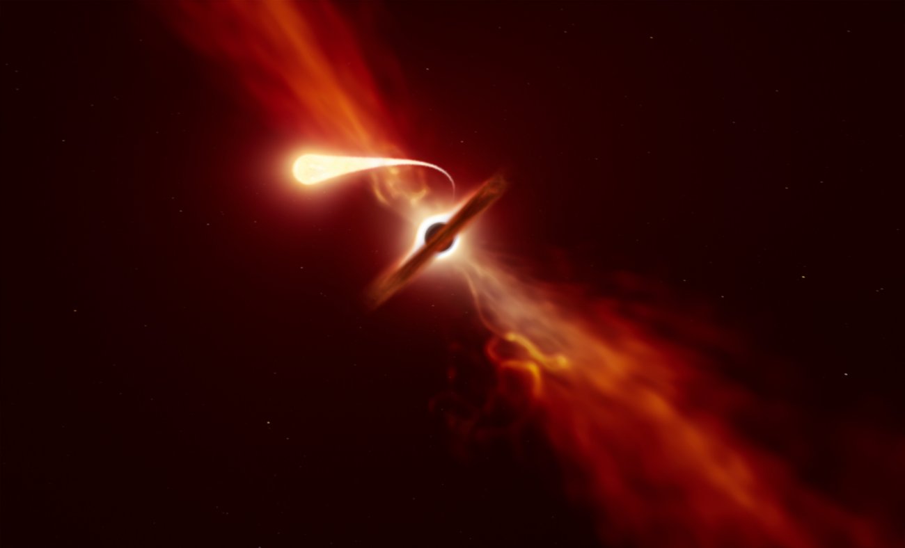 Na ilustracji: wizja artystyczna jak supermasywna czarna dziura niszczy gwiazdę, która za bardzo zbliżyła się. Niczym spagetti gwiazda zostaje rozciągnięta (t.j. rozciągnięta „łezka” na pierwszym planie) i rozerwana przez potężne siły pływowe czarnej dziury zanurzonej w dysku gazowo-pyłowym, który tutaj jest widziany z boku. Astronomowie nazywają to zjawiskiem rozerwania pływowego TDE (skrót z j.ang. Tidal Disruption Event). Źródło: ESO/M. Kornmesser
