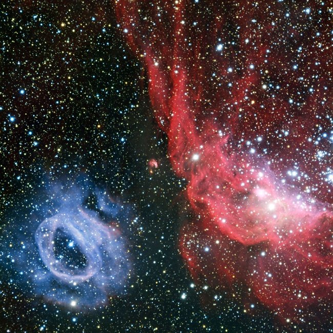 VLT (Very Large Telescope) z ESO (European Southern Observatory) wykonał szczegółową fotografię obszaru formowania się nowych gwiazd w Wielkim Obłoku Magellana – jednej z tzw. galaktyk satelitarnych Drogi Mlecznej. Na powyższym, wyraźnym obrazie widoczne są dwie świecące chmury gazu. NGC 2014 (po prawej) ma kształt nieregularny i czerwoną barwę, podczas gdy jej sąsiadka, NGC 2020, jest okrągła i błękitna. Te nietypowe i całkowicie różne formy zostały wyrzeźbione przez silne wiatry gwiazdowe pochodzące od ba
