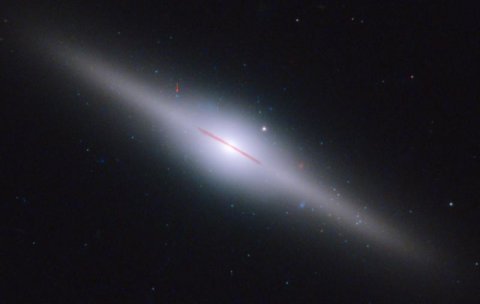 Galaktyka ESO 243-49, leżąca 300 milionów lat świetlnych od Ziemi, ma w swym centrum nowo odkrytą czarną dziurę HLX-1 o masie pośredniej. Strzałka wskazuje jej dokładną lokalizację. Źródło: NASA, ESA and S. Farrell (U. Sydney).