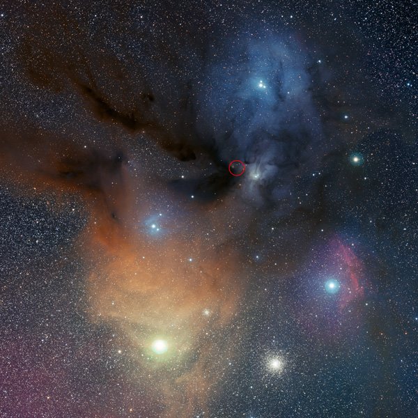 Fotografia obłoków Rho Ophiuchi wykonana w Obserwatorium Paranal powstała po złożeniu trzech obrazów w filtrach : B, V i R. To właśnie w tym obszarze formowania gwiazd wykryto nadtlenek wodoru (czerwone kóleczko). Źródło ESO/S.Guisard