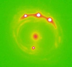 Zniekształcony obraz optyczny jednego z obserwowanych kwazarów. Plama w centrum to soczewkująca galaktyka, cztery jasne plamy to obrazy tego samego obiektu. 