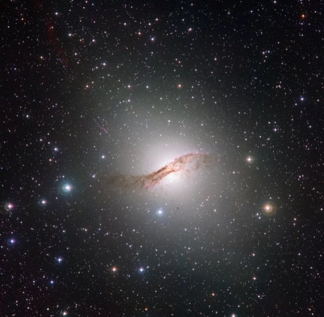 Astronom John Herschel odkrył galaktykę Centaurus A, która leży w odległości koło 13 milionów lat świetlnych od nas, obserwując południowe niebo w latach 1834-1838. Opisał ją jako niezwykłą mgławicę przeciętą szerokim i ciemnym pasmem. Na obrazie w świetle optycznym te smugi, które w rzeczywistości stanowi głównie pył, są wyraźnie widoczne. Źródło: ESO