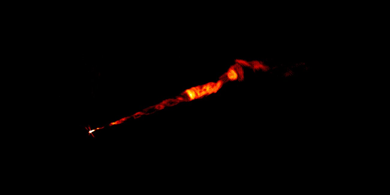 Na ilustracji: obraz dżetu radiowego w galaktyce M87 wykonanego przez sieć radioteleskopów VLA na wielu częstotliwościach. Dżet ma długość około 8000 lat świetlnych. W wewnętrznej części dżetu widać skręconą spiralnie strukturę helisy, czyli linię śrubową podobną do korkociągu. Źródłem dżetu jest supermasywna czarna dziura znajdująca się w centrum M87 (jasna plama po lewej stronie). Źródło: Pasetto et al., Sophia Dagnello, NRAO/AUI/NSF
