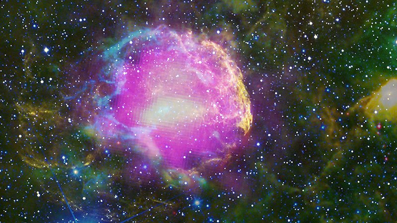 Na ilustracji: wielobarwny obraz Mgławicy Meduza będącej pozostałością po wybuchu supernowej, która znajduje się w odległości około 5 tysięcy lat świetlnych. Jasne, zielono-niebieskie pętle reprezentują obszary, w których następuje oddziaływanie rozszerzającej się otoczki po wybuchu supernowej z gęstą materią wokółgwiazdową. Źródło: NASA/DOE/Fermi LAT Collaboration, NOAO/AURA/NSF, JPL-Caltech/UCLA