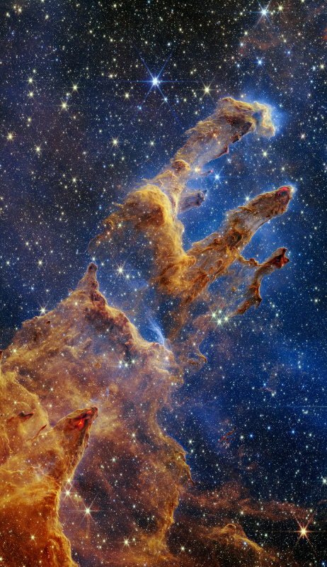 Na ilustracji fragment Mgławicy Orzeł (M16) zwany Filarami Stworzenia sfotografowany przez Kosmiczny Teleskop Jamesa Webba w bliskiej podczerwieni (0,9 - 4,7 mikrona), gdzie występują łuki i wiry wypełnione półprzeźroczystym gazem i pyłem. Jest to obszar powstawania młodych gwiazd. Widać tutaj trzy „słupy” („filary”) gazowo-pyłowe rozciągające się w prawo do góry. Lewy słup jest największy i najszerszy. Źródło: NASA, ESA, CSA, STScI; Joseph DePasquale (STScI), Anton M. Koekemoer (STScI), Alyssa Pagan (STScI