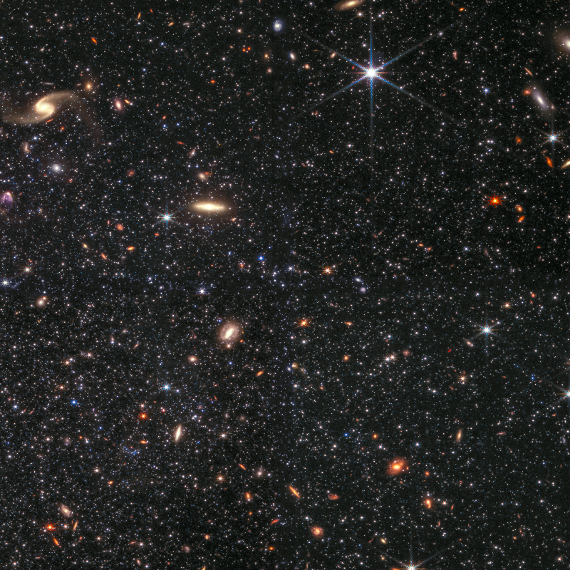 Zdjęcie wykonane przez kamerę NIRCam Kosmicznego Teleskopu Jamesa Webba, na którym widać fragment karłowatej galaktyki nieregularnej Wolf-Lundmark-Melotte, jak również w tle wiele galaktyk. To zdjęcie pokazuje niezwykłą zdolność teleskopu Webba do detekcji słabych gwiazd poza Drogą Mleczną. Pole widzenia obejmuje około 2’ (~1700 l.św. przy odległości do galaktyki WLM). Źródło: NASA / ESA / CSA / STScI / K. McQuinn, Rutgers University / A. Pagan, STScI.
