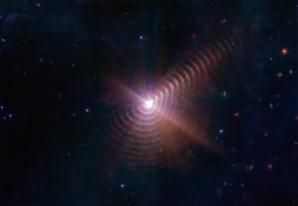 Uzyskany przez Kosmiczny Teleskop Jamesa Webba widok kosmicznego „odcisku palca” na sferze niebieskiej o wielkości aż ponad 1 rok świetlny. Są to pierścienie pyłowe wokół układu WR 140, który składa się z gwiazd masywnych (gwiazda Wolfa-Rayeta + gwiazda O). Wokół tego układu co osiem lat powstaje warstwa pyłu, która wygląda jak pierścień. Każdy taki pierścień powstaje podczas kolizji wiatrów gwiazdowych, gdy obie gwiazdy zbliżają się do siebie w ruchu orbitalnym. Źródło: NASA/ESA/CSA/STScl/JPL-Caltech