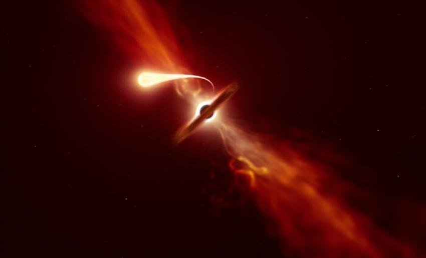Ilustracja przedstawia gwiazdę (na pierwszym planie) doświadczającą spaghettyzacji, gdy jest zasysana przez supermasywną czarną dziurę (w tle) podczas zdarzenia “rozerwania pływowego".