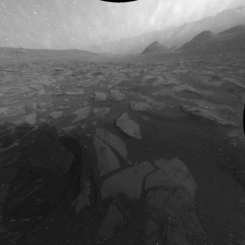 Podczas dwutygodniowego przymusowego "postoju" na Marsie w listopadzie 2023 roku łazik Curiosity wykorzystał przednią i tylną kamerę Hazcam do uchwycenia 12 godzin marsjańskiego dnia. Na zdjęciach wykonanych przez przednią kamerę Hazcam widoczny jest cień łazika. (NASA)