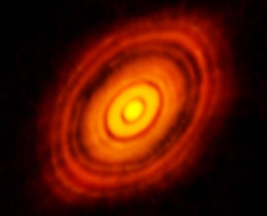 ALMA (Atacama Large Millimeter/submillimeter) ujawnia kilka przerw w pyłowym dysku otaczającym gwiazdę HL Tau. Ich obecność zaskoczyła astronomów jeszcze w roku 2014 roku jako pośredni dowód na zachodzący tam proces formowania się planet. Możliwe jest jednak, że luki te mogą nie być związane z planetami. Źródło: ALMA (ESO / NAOJ / NRAO)