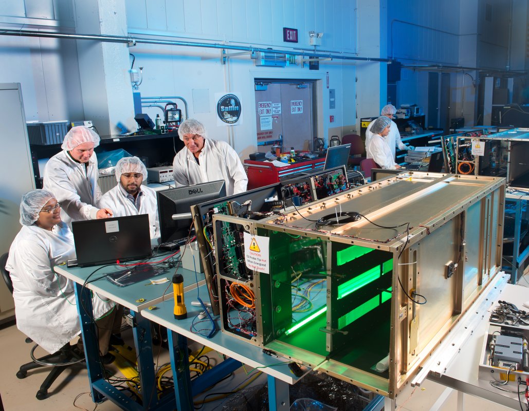 Grupa naukowców i inżynierów podczas testów urządzeń eksperymentu Saffire-II i Saffire-I (w tle). Żródło: NASA