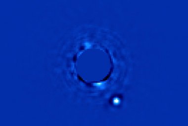 Ta jasna, biała plamka to planeta pozasłoneczna Beta Pictoris b, świecąca w podczerwieni na skutek wydzielania ciepła podczas jej formowania się, które miało miejsce 10 milionów lat temu. Jaśniejsza gwiazda macierzysta Beta Pictoris ukrywa się pod specjalną maską, widoczną w centrum fotografii. Źrodło: Christian Marois, NRC Canada