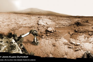 Ramię łazika Curiosity na tle Czerwonej Planety.  Właśnie to ramię badało w styczniu 2013 skałę o nazwie John Klein. W lutym tego roku udało się wykonać odwiert w tej skale i pobrać pierwsze w historii próbki z wnętrza marsjańskiej skały. Źródło: strona Kena Kremera