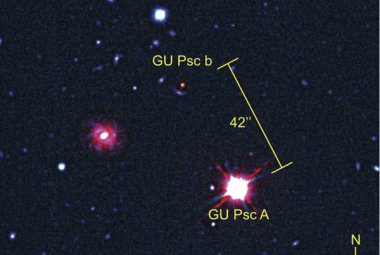 Planeta GU Psc b i jej macierzysta gwiazda, GU Psc widziane jako złożenie obrazów w świetle widzialnym i w podczerwieni (teleskopy Gemini South i CFHT). Ponieważ światło podczerwone jest niewidoczne dla ludzkiego oka, astronomowie użyli specjalnego kodu barwnego, w którym podczerwień jest sztucznie reprezentowana przez kolor czerwony. GU Psc b jest w podczerwieni jaśniejsza niż w innych filtrach, zatem jest na tym zdjęciu silnie poczerwieniona.