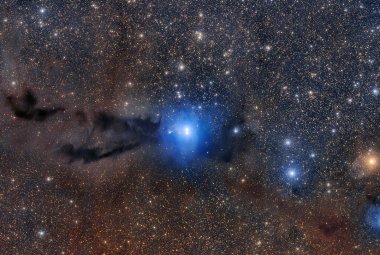 Młode gwiazdy oświetlają ciemne, pyłowe obłoki w regionie gwiazdotwórczym Lupus 3, odległym o około 600 lat świetlnych stąd.