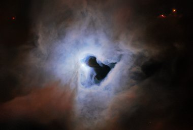 Widok mgławicy refleksyjnej NGC 1999 w gwiazdozbiorze Oriona odległej o około 1350 l.św. W pobliżu centrum mgławicy jest widoczna ciemna „dziura”, która przypomina dziurkę od klucza. Jest to obraz uzyskany Kosmicznym Teleskopem Hubble’a o polu widzenia 2.78’ x 2.97’. Dodatkowo wykorzystano dane z instrumentu OmegaCAM na VLT Survey Telescope (obserwatorium ESO). Źródło: NASA / ESA / Hubble / ESO / K. Noll