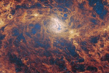 Na ilustracji: Zdjęcie galaktyki spiralnej z poprzeczką M83 (Galaktyka Południowy Wiatraczek) w średniej podczerwieni (~5μm-28μm) wykonane przez kamerę MIRI współpracującą z Teleskopem Webba. Widać dwa spiralne ramiona rozchodzące się poziomo od jądra galaktyki znajdującego się w centrum zdjęcia.Kolory są dobrane arbitralnie na zdjęciu, ponieważ ludzkie oko nie widzi w podczerwieni. Źródło: ESA/Webb, NASA & CSA, A. Adamo (Stockholm University) and the FEAST JWST team