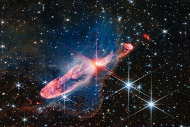 Teleskop Webba sfotografował w wysokiej rozdzielczości za pomocą kamery NIRCam (bliska podczerwień) ściśle ze sobą związaną, aktywną parę tworzących się gwiazd, znaną jako obiekt Herbig-Haro 46/47 (HH 46/47). Rodzące się gwiazdy znajdują się w centrum zdjęcia w pobliżu miejsca, skąd wychodzą charakterystyczne czerwone promienie dyfrakcyjne („spajki”) będące efektem instrumentalnym spowodowanym konstrukcją Teleskopu Webba. Źródło: NASA, ESA, CSA, Joseph DePasquale (STScI)