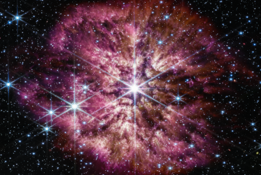 Gwiazda Wolf Rayet 124 (WR 124) jest widoczna w środku połączonego zdjęcia z Teleskopu Webba obejmującego zakres bliskiej (kamera NIRCam) i średniej (MIRI) podczerwieni. Gwiazda centralna prezentuje charakterystyczne promienie dyfrakcyjne („spajki”) na zdjęciu uzyskanym przez kamerę NIRCam, które są efektem instrumentalnym spowodowanym konstrukcją Teleskopu Webba. Na zdjęciu z NIRCam jasność gwiazdy WR124 jest zrównoważona ze słabiej świecącym gazem i pyłem ją otaczającym.Źródło: NASA, ESA, CSA, STScI, Webb