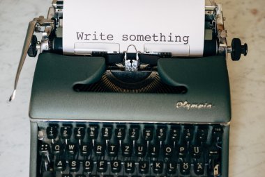 Maszyna do pisania z kartką papieru z napisem "Write something"